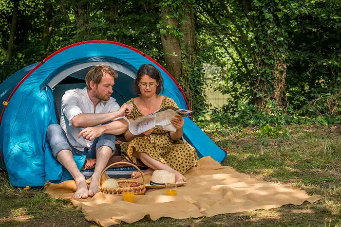 Un couple dans une tente sur un emplacement du camping de Coulvée en Anjou.