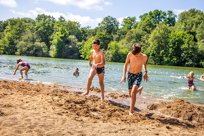 Deux enfants courent sur la plage du camping de coulvée | Camping baignade